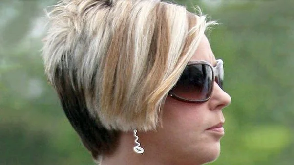 Side view of a woman with a short layered blonde bob and dark sunglasses